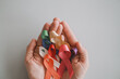 © SewcreamStudio - Hands holding color ribbons, world cancer day, World Autism Awareness Day concept