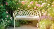 © Tati - Serene garden bench surrounded by vibrant flowers, perfect for relaxation