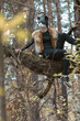 © junky_jess - Woman in quadrober costume in a cats mask and fur vest sits on tree branch in the forest, vertical image.