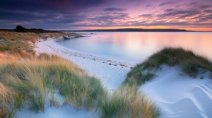 Sticker - Serene beach at sunset with tranquil water and dunes.