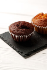 Wall Mural - Delicious chocolate and vanilla muffins displayed on a black slate plate in a bright kitchen setting