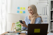 © Wicitr - Smiling Muslim Businesswoman using Smartphone