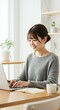 © Yuudaishin - Professional Japanese Freelancer in Her 20s or 30s with Sleek Updo Hairstyle Typing on a Laptop in a Bright Home Office