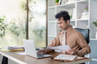 © Natee Meepian - Business professional working at desk modern office digital workspace bright environment focused viewpoint productivity concept