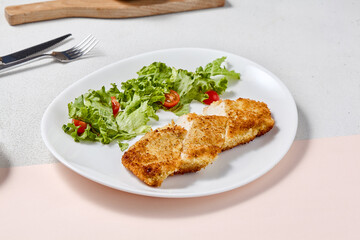 Wall Mural - Crispy Chicken Fillet with Cheese Crust and Fresh Salad in Minimalist Style