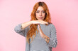 © luismolinero - Young caucasian woman isolated on pink background making time out gesture