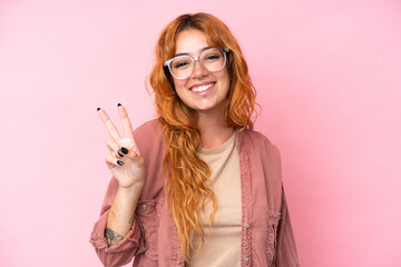 Wall Mural - Young caucasian woman isolated on pink background With glasses and doing OK sign