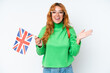 © luismolinero - Young caucasian woman holding an United Kingdom flag isolated on white background with shocked facial expression