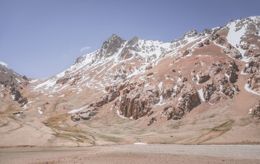 Wall Mural - Panorama of the mountain range in the Pamirs in Tajikistan with snow and glaciers, texture and relief of red rocks on a sunny summer day in the highlands