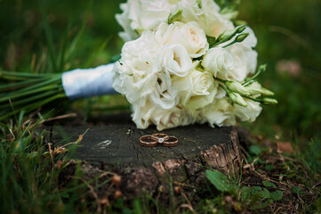 Wall Mural - Elegant Wedding Rings and Bouquet on Rustic Wood Slice