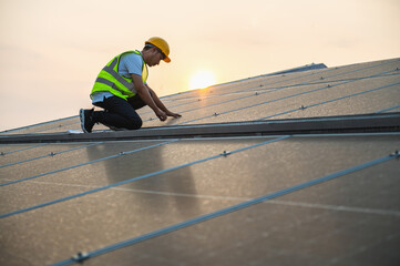 Wall Mural - man in a yellow vest is working on a solar panel