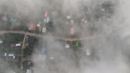 Wall Mural - Aerial view of small village in Pa Daet district in Chiang Rai province of Thailand covered with fog in winter season. 