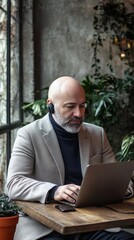 Aufkleber - Confident man working on his laptop in a minimalist cafe surrounded by plants