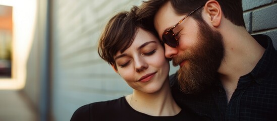 Romantic young hipster couple embracing in urban setting with soft-focus background, stylish black dress, warm sunlight creating intimate atmosphere