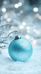 Aufkleber - Vibrant turquoise ornament resting on snow with sparkling lights in the background