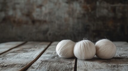 Poster - Wool balls on rustic wooden table with textured background highlighting craftsmanship and natural materials in soft light