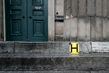 Abstract, yellow Hydrant sign seen attaching to stonework steps which lead to an on English museum entrance. The entrance is to a famous city museum in the historic city of York, UK.