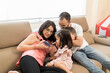 © Daniel Gonzalez/Stocksy - Family watching video on smartphone
