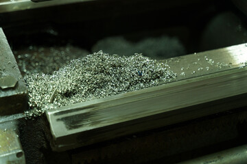Poster - Shimmering metal shavings scatter across a lathe at a bustling workshop