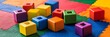 © TANVEER - A set of interlocking building blocks in bold primary colors scattered on a vibrant play mat