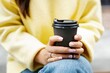 © Oleksii Syrotkin/Stocksy - Cropped view of woman holding cup of coffee, sitting and resting