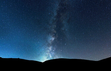 Wall Mural - Beautiful bright milky way galaxy under the mountains. Night landscape.