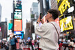 © Alvaro Lavin/Stocksy - Tourist taking photos of times square billboards in new york city