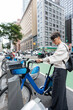 © Alvaro Lavin/Stocksy - Businesswoman renting electric bike in new york city sharing system