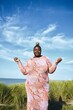 © Studio Sincère/Stocksy - Woman balancing an apple on her head by the beach