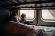 © Santi Nuñez/Stocksy - Mother and child inside a camper van looking out the window