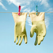 © Vaidas Bucys/Stocksy - Rubber gloves hanging from a clothesline with clothespins