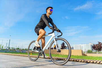 Cyclist enjoying a sunny day while riding a sleek bicycle on a city pathway