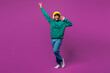 © ViDi Studio - Full body young happy Indian man he wear green hoody yellow hat casual clothes listen to music in headphones raise up hands dance isolated on plain purple background studio portrait Lifestyle concept