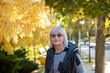 © Olena Smyrnova/Stocksy - Elderly attractive woman on a walk in the autumn park