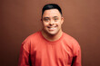 © Santi Nuñez/Stocksy - Man with Down syndrome smiling on brown background