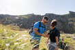 © Alvaro Lavin/Stocksy - Hikers using smartphone gps app while hiking in mountain landscape