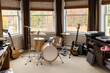 © Raymond Forbes LLC/Stocksy - Drum set and guitar in child home bedroom window