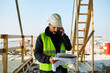 © Ivan Jovanovic/Stocksy - Construction site manager talks on the phone