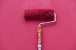 © J.Rynio PHOTOGRAPHY/Stocksy - A paint roller rests on a pink wall
