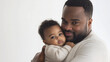© sabyna75 - Heartwarming moment of father cuddling baby in studio portrait for family love theme