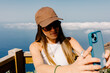 © Adrian Rodd/Stocksy - Woman take a selfie from the top of La Peña viewpoint in El Hierro