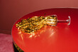 © Ulas&Merve/Stocksy - Spilled Wine Glass with Gold Confetti on Red Table