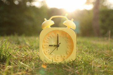 Aufkleber - Yellow alarm clock on green grass outdoors