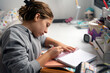 © Albert Martinez/Stocksy - Student doing homework in his room