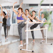 © JackF - Group of women beginners doing stretching exercises at barre in dance studio