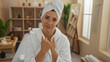 © Krakenimages.com - Mature woman enjoying a relaxing moment at a wellness spa center, wrapped in a white towel with a serene smile, surrounded by soothing indoor spa decor.