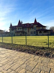 Wall Mural - Wooden fairy tale house against the background of blue sky and green grass