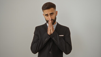 Young hispanic man in a black suit with hands together over isolated white background