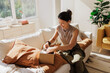 © BONNINSTUDIO/Stocksy - Happy woman opening parcel in bright living room