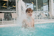 © Danil Rudenko/Stocksy - Boy splashing in indoor pool